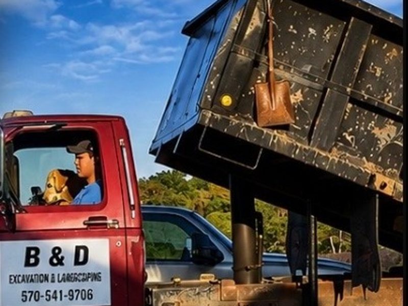 Red dump truck with its bed raised